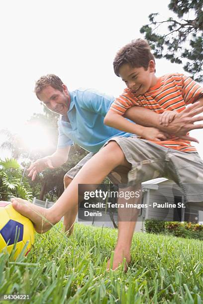 father and son playing soccer in backyard - barefeet soccer stock pictures, royalty-free photos & images