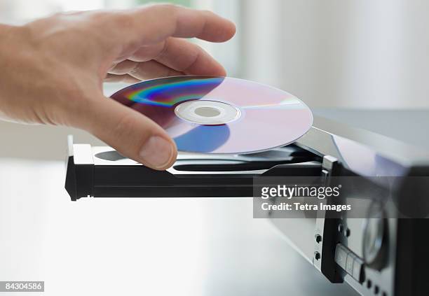 man inserting dvd - dvd speler stockfoto's en -beelden