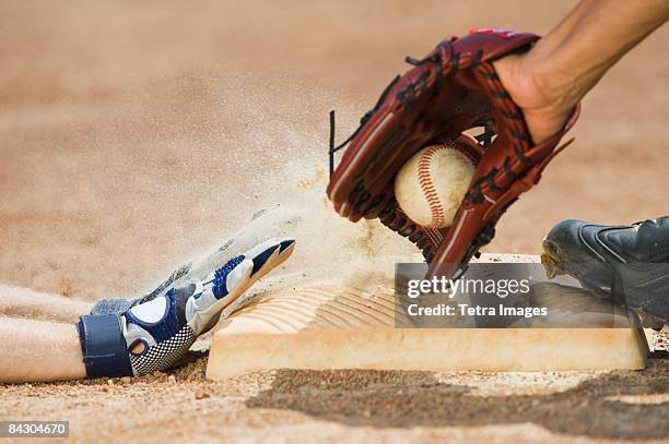 baseball player sliding into home base - base sports equipment fotografías e imágenes de stock