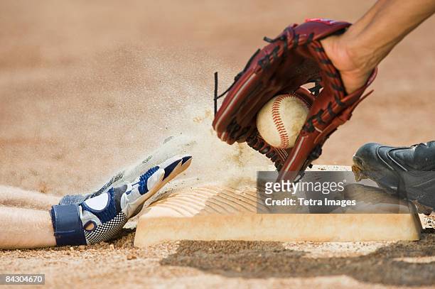 baseball player sliding into home base - basebollhandske bildbanksfoton och bilder