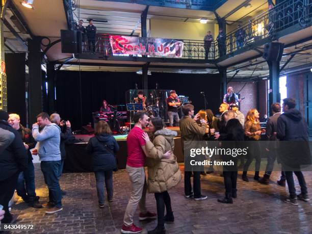 la gente beve e balla nel mercato del pesce al coperto di amburgo. - fischmarkt hamburg foto e immagini stock