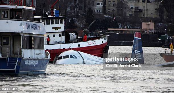 Rescue boats float next to a US Airways plane floating in the water after crashing into the Hudson River in the afternoon on January 15, 2009 in New...