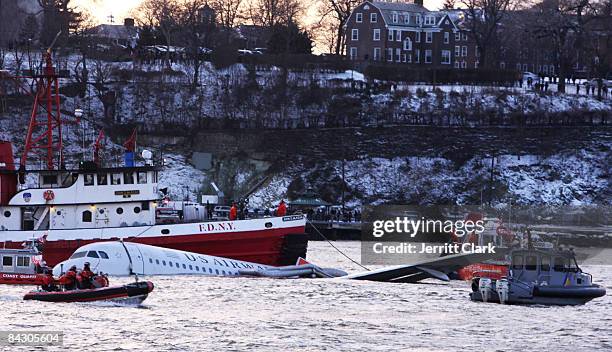 Rescue boats float next to a US Airways plane floating in the water after crashing into the Hudson River in the afternoon on January 15, 2009 in New...