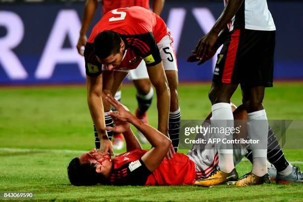 Egypts Amr Gamal reacts on the ground after he was injured during the FIFA World Cup 2018 qualification football matchh between Egypt and Uganda at...