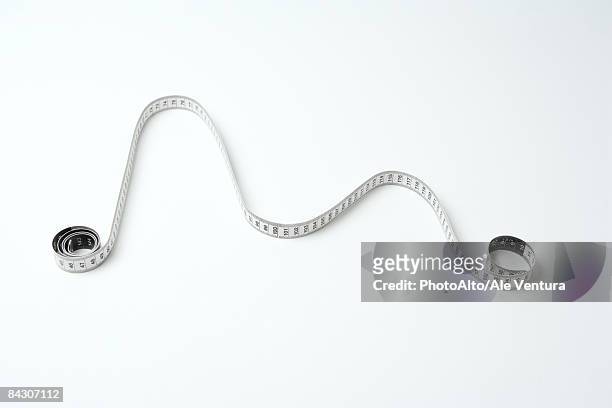 measuring tape, coiled at either end, arranged to mimic line graph, high angle view - style studio day 1 stockfoto's en -beelden