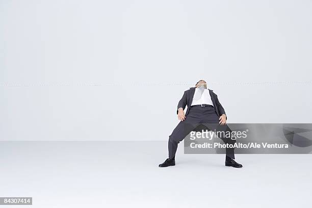 businessman doing limbo, bending backwards to go under rope - limbo blanco fotografías e imágenes de stock