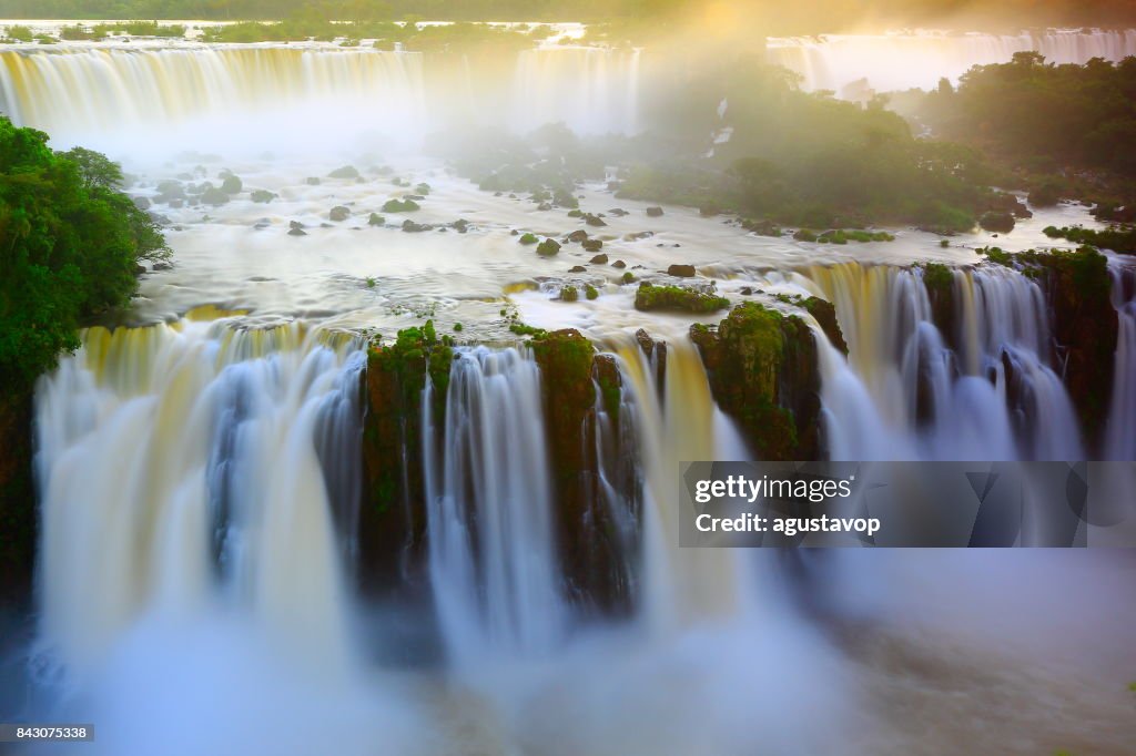 Cai de Iguaçu impressionante paisagem, movimento borrado de longa exposição ao dramático pôr do sol - garganta do diabo idílica - fazer de fronteira internacional brasileira de Foz do Iguaçu, Paraná, Argentina Puerto Iguazu, Misiones e Paraguai - América do Sul