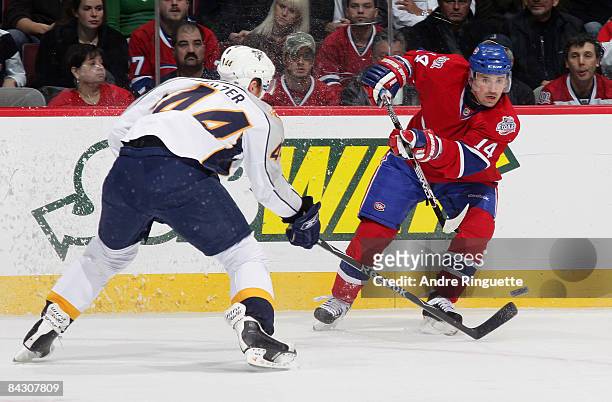 Tomas Plekanec of the Montreal Canadiens passes the puck over the stick of Alexander Sulzer of the Nashville Predators at the Bell Centre January 15,...
