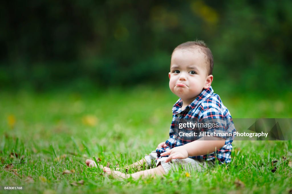 12 month Beautiful Fraternal Twin Baby Sits in Grass