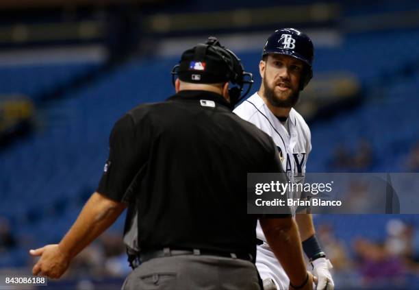 Steven Souza Jr. #20 of the Tampa Bay Rays has a discussion with home plate umpire Eric Cooper after striking out looking to pitcher Bartolo Colon of...