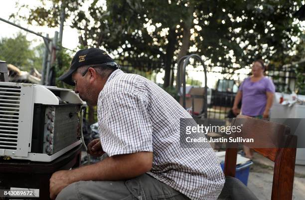 Lino Saldana tries to repair a broken air conditioner in front of his flood damaged home on September 5, 2017 in Houston, Texas. Over a week after...