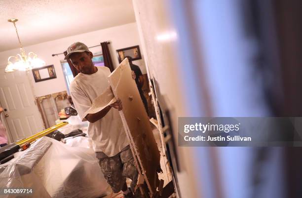 Donnie Carter of Top to Bottom Home Renovations removes moldy drywall from a flood damaged home that he is cleaning out on September 5, 2017 in...