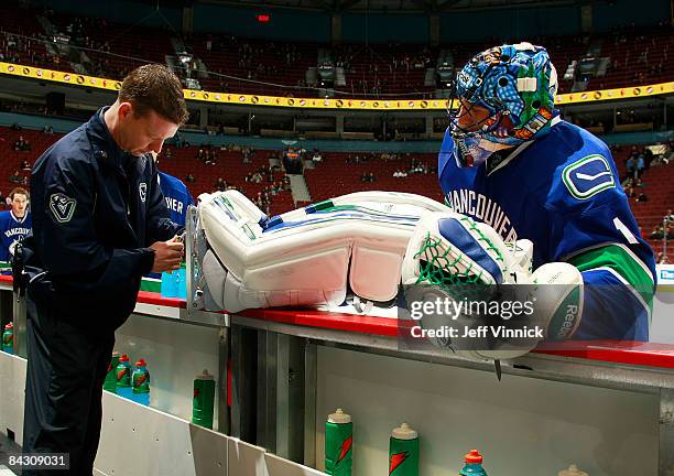 Roberto Luongo of the Vancouver Canucks has his skate sharpened by equipment manager Jamie Hendricks before their game against the Phoenix Coyotes at...