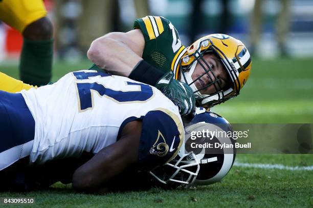 Jake Ryan of the Green Bay Packers tackles Justin Davis of the Los Angeles Rams in the first quarter during a preseason game at Lambeau Field on...