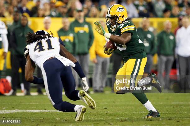 Aaron Jones of the Green Bay Packers runs with the ball while being chased by Marqui Christian of the Los Angeles Rams in the fourth quarter during a...