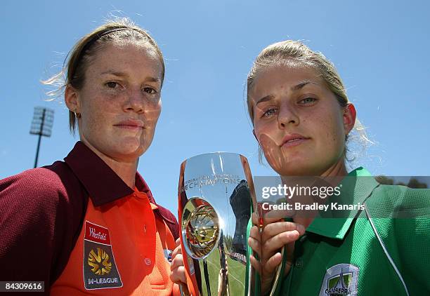 Kate McShae of the Queensland Roar and Ellie Brush of Canberra United hold the inaugural W-League trophy before attending a press conference at...
