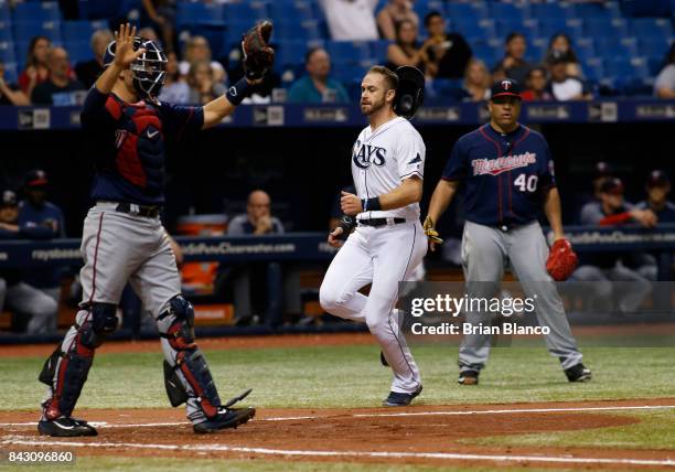 Evan Longoria of the Tampa Bay Rays runs home in front of catcher Jason Castro of the Minnesota Twins and pitcher Bartolo Colon to score off of an...