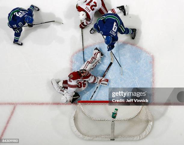 Taylor Pyatt of the Vancouver Canucks hits the post as Ilya Bryzgalov and David Hale of the Phoenix Coyotes and Daniel Sedin of the Vancouver Canucks...