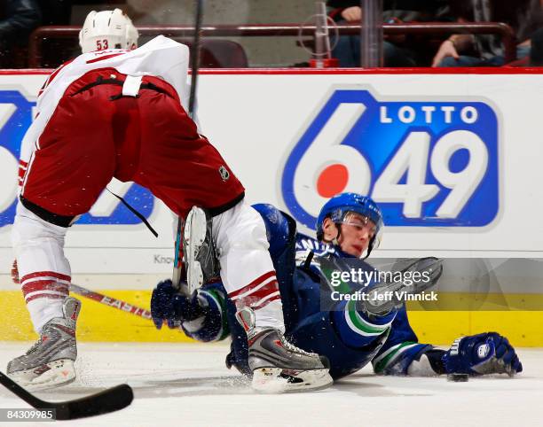 Alex Burrows of the Vancouver CanucksÊis checked to the ice by Derek Morris of the Phoenix Coyotes during their game at General Motors Place on...