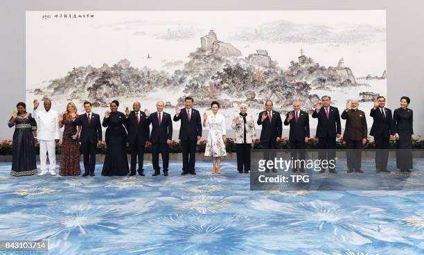 Chinese President Xi Jinping and his wife Peng Liyuan pose for a group photo with leaders attending the 9th BRICS Summit and the Dialogue of Emerging...