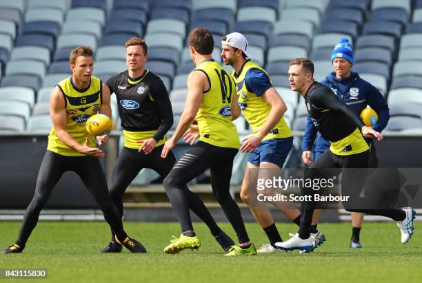 Joel Selwood of the Cats competes for the ball as Lachie Henderson of the Cats passes the ball during a Geelong Cats AFL training session at Simonds...