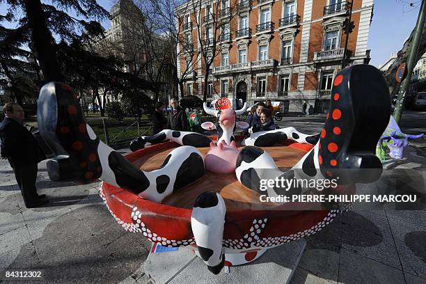 People look at a painted cow, created by Spanish artists and exhibited in Madrid, on January 16, 2009 for the first day of the Cow Parade. AFP PHOTO/...