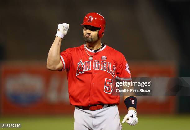 Albert Pujols of the Los Angeles Angels reacts after hitting an RBI single in the fifth inning against the Oakland Athletics at Oakland Alameda...