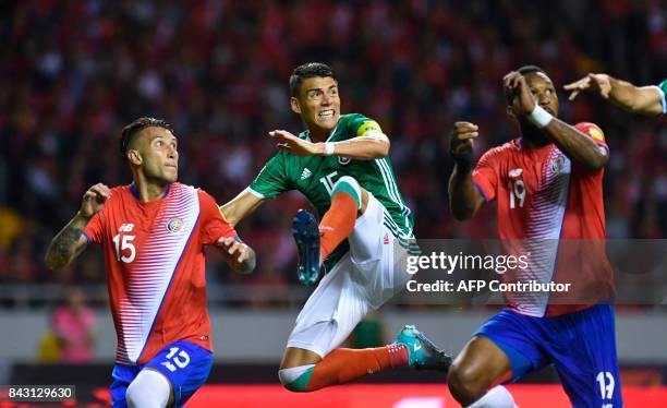 Mexico's Diego Reyes and Costa Rica's Francisco Calvo and Kendall Waston jump for the ball during their 2018 World Cup qualifier football match in...