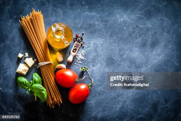 spagetti met ingrediënten op donkere tafel - pasta tomato basil stockfoto's en -beelden