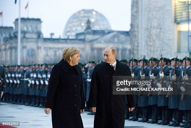 German Chancellor Angela Merkel and Russian Prime Minister Vladimir Putin review an honour guard during an official welcoming ceremony at the...
