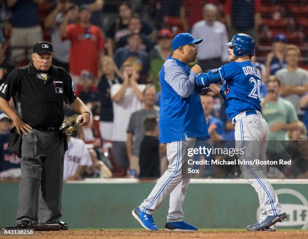 Josh Donaldson of the Toronto Blue Jays is restrained by bench coach DeMarlo Hale after being ejected from a game against the Boston Red Sox for...