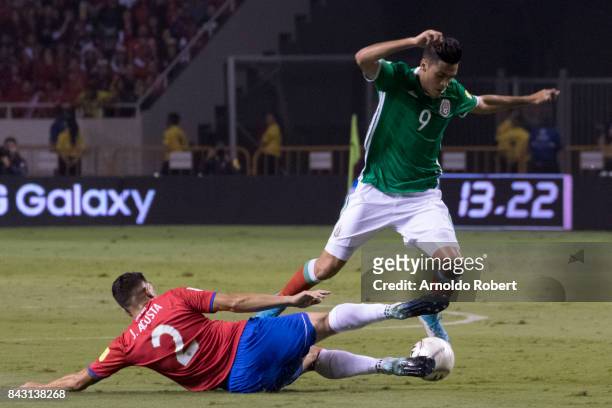 Raul Jimenez of Mexico tries to avoid the slide by Johnny Acosta of Costa Rica during the match between Costa Rica and Mexico as part of the FIFA...