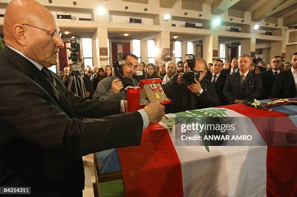 Lebanese Culture Minister Tamam Salam places medals of honour on the coffin of late Lebanese composer Mansour Rahbani during his funeral at a church...