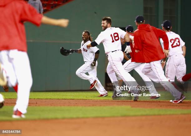 The Boston Red Sox team chases Hanley Ramirez of the Boston Red Sox after he hits an RBI single in the bottom of the nineteenth inning to win the...
