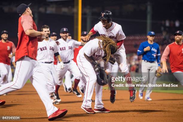 Hanley Ramirez of the Boston Red Sox is mobbed by Mookie Betts and teammates during the nineteenth inning of a game against the Toronto Blue Jays on...