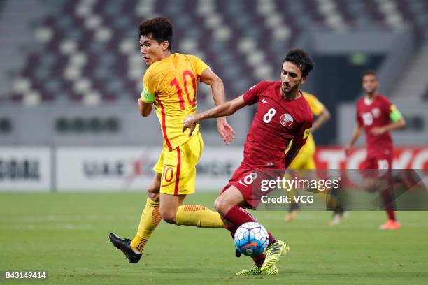 Ali Assad of Qatar and Zheng Zhi of China vie for the ball during the 2018 FIFA World Cup qualifier game between Qatar and China at Khalifa...