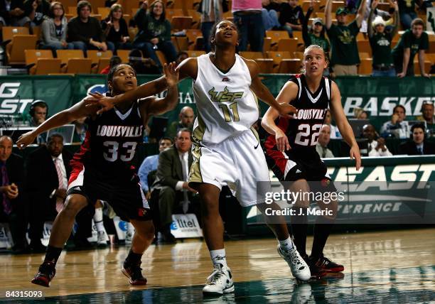 Porche Grant of the South Florida Bulls battles for a rebound with Monique Reid and Brandie Radde of the Louisville Cardinals during the game at the...