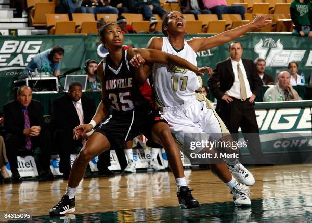 Porche Grant of the South Florida Bulls battles for a rebound with Angel McCoughtry of the Louisville Cardinals during the game at the SunDome on...