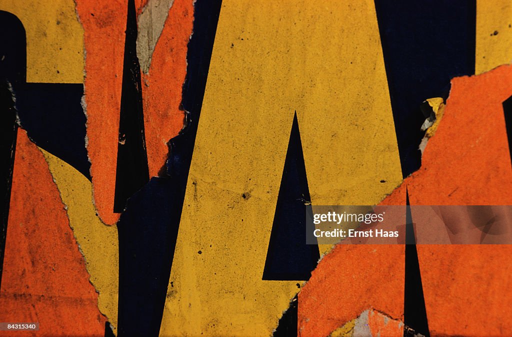 An abstract close-up of fragmented lettering in layers of torn... News ...