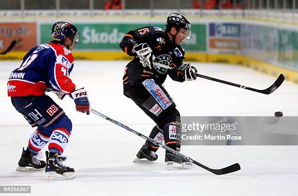 Andreas Morczinietz of Wolfsburg and Felix Petermann of Mannheim compete for the puck during the DEL match between Grizzly Adams Wolfsburg and Adler...