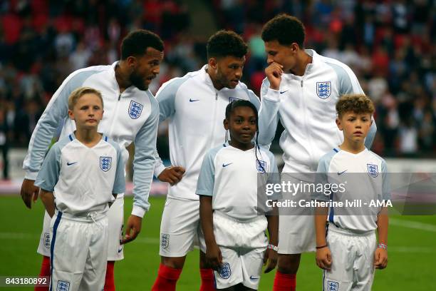 Dele Alli of England whispers to Ryan Bertrand and Alex Oxlade-Chamberlain of England during the FIFA 2018 World Cup Qualifier between England and...