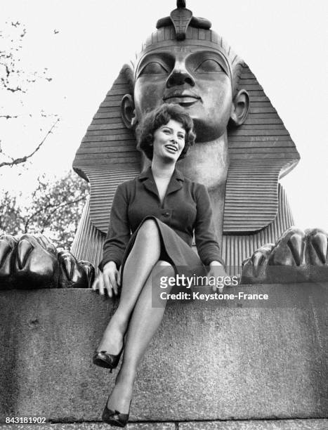 Sophia Loren, pose sur un Sphinx de 'L'Aiguille de Cléopâtre', monument situé sur le bord de la Tamise, à Londres, Royaume-Uni, le 19 octobre 1957.