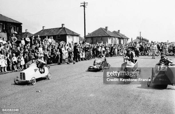 La foule amassée au bord de la route regarde la demi finale de la course de caisses à savon des scouts organisée à Salford, Manchester, Royaume-Uni...