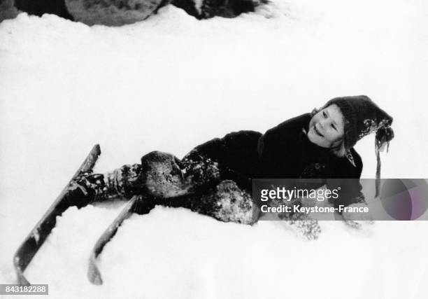 Cette petite fille qui prend sa première leçon de ski fait une chute, en France en décembre 1951.