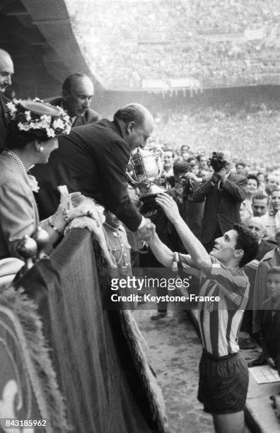 Franco remet la coupe au capitaine de l'équipe de football junior de Madrid après sa victoire contre Saragosse le 24 juin 1956 à Madrid, Espagne.