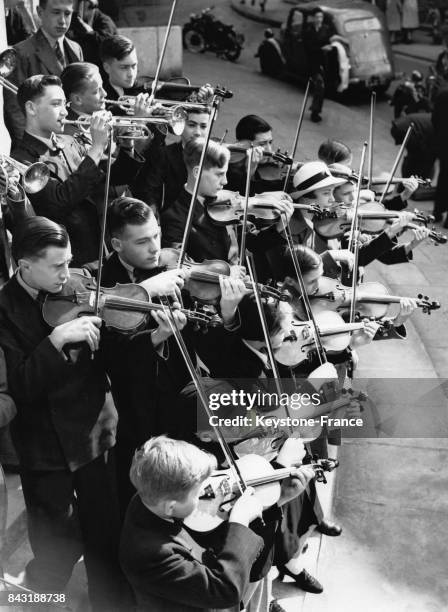 Des écoliers britanniques s'entraînent sur les marches du Queen's Hall pour le festival des orchestres des écoles le 11 juin 1938 à Londres,...