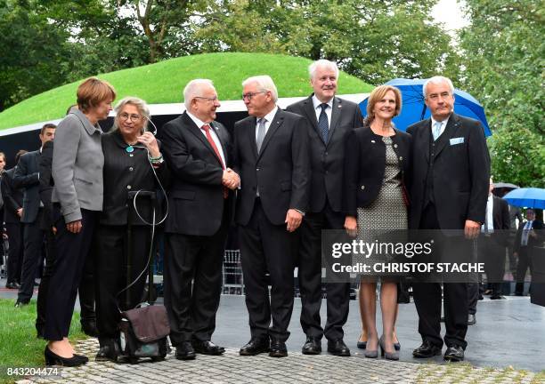 Israeli President Reuven Rivlin and German President Frank-Walter Steinmeier shake hands as they pose with wife of German President Elke...