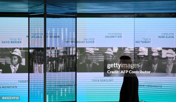 Visitor looks at the portraits of the Israeli athletes murdered at the 1972 Munich Olympics at the Olympic Village displayed inside the Memorial...