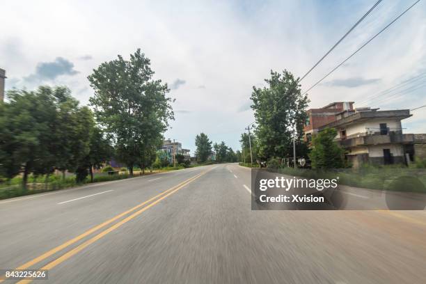 asphalt road with double yellow line in motion blur in the rural - car racing blurred motion bildbanksfoton och bilder