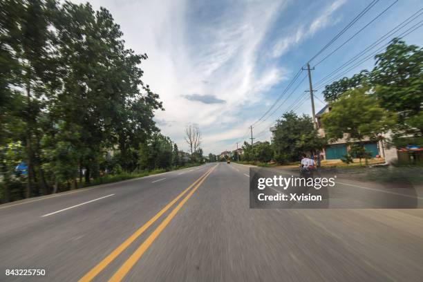 asphalt road with double yellow line in motion blur in the rural - car racing blurred motion bildbanksfoton och bilder